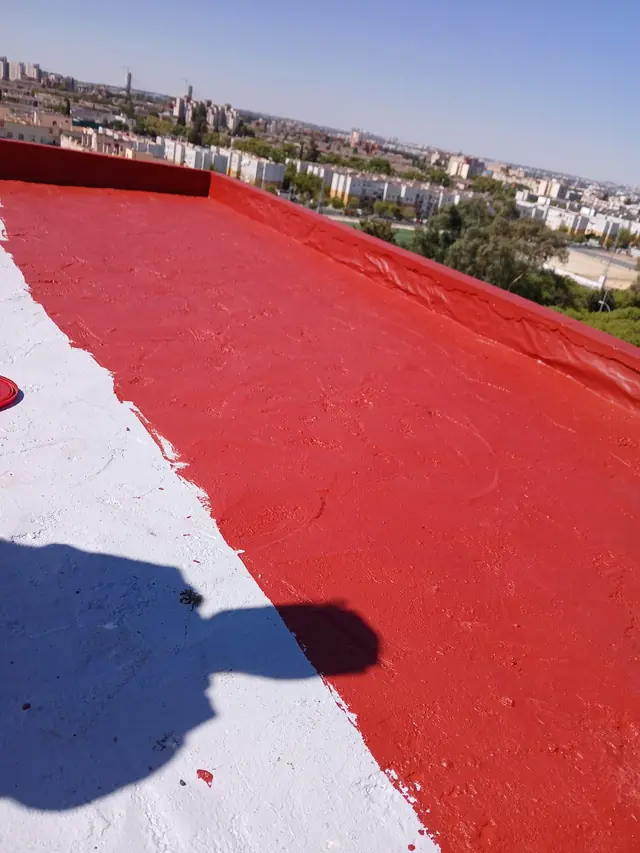 Azotea impermeabilizada con caucho rojo sobre imprimación blanca