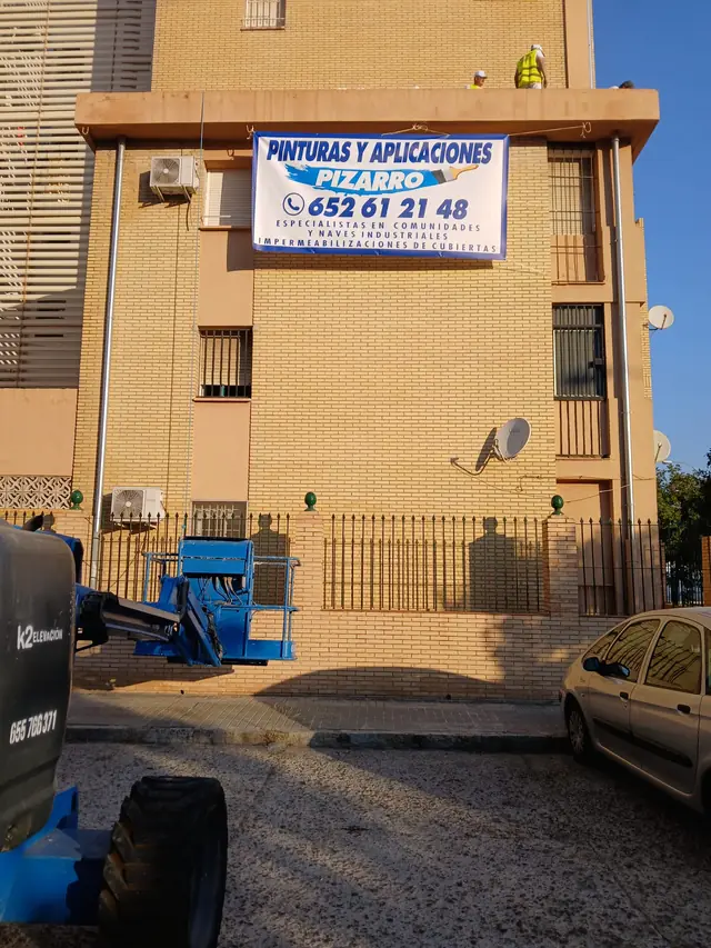 Bloque de viviendas con la lona de Pinturas y Aplicaciones Pizarro durante una obra